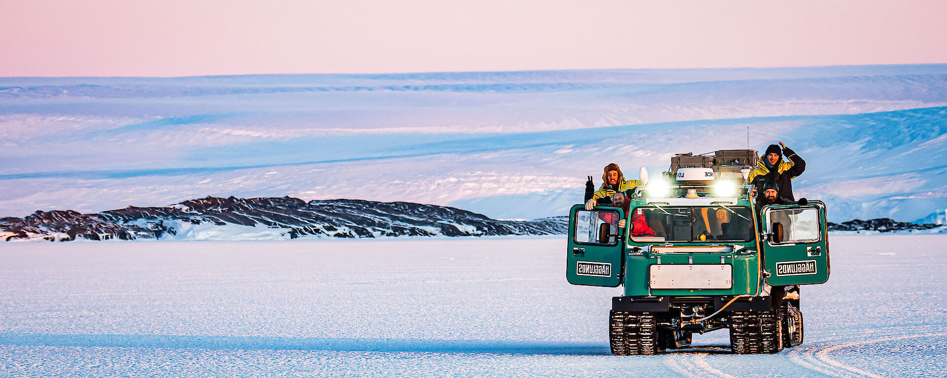 4 expeditioners drive Hagglunds vehicle on the ice.