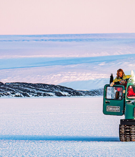 4 expeditioners drive Hagglunds vehicle on the ice.