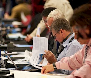 Delegates at table reading papers