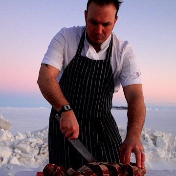 Davis station Chef slicing up scotch fillet. (Photo: David Hosken) Chef slicing up scotch fillet with sunset over fast ice