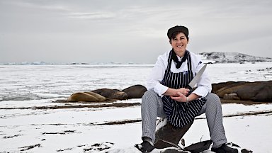 Chef posing outside the station in the snow with her knife