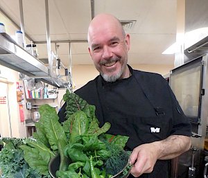 Chef with standing with dishes of fresh produce from hydroponics