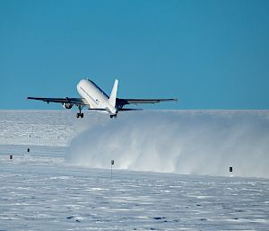An aeroplane takes off from an ice runway.