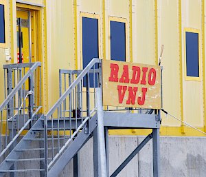 Yellow building with 'Radio VNJ' sign.
