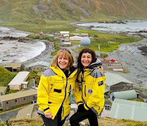 Two expeditioners on a hill overlooking the Macquarie Island station