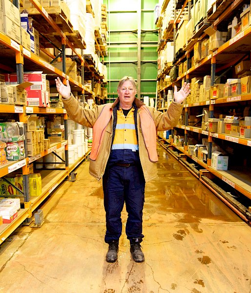 Man standing in warehouse with arms outstretched.