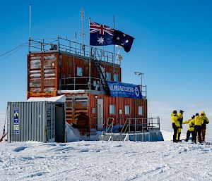 A building made out of shipping containers flies the Australian flag and says "Wilkins Aerodrome" on a sign.