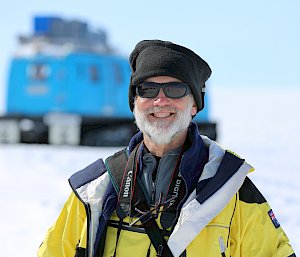 Medical officer in sunglasses with blue over-snow vehicle in background.