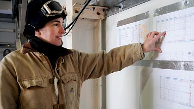 Expeditioner pointing at a chart on the wall