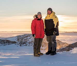 Woman and man posing in icy landscape.