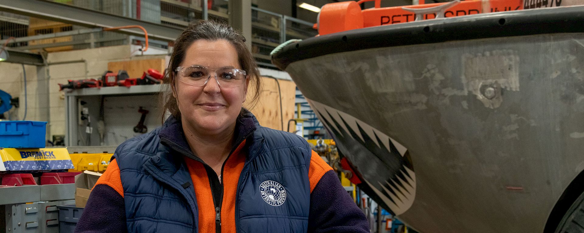 Woman in high visibility clothing posing in a workshop