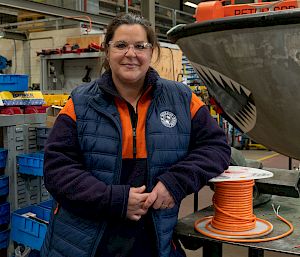 Woman in high visibility clothing posing in a workshop