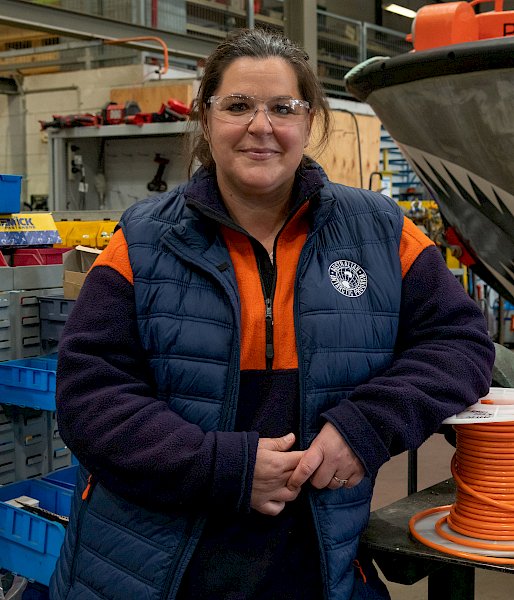 Woman in high visibility clothing posing in a workshop