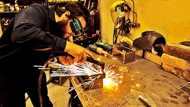 Person welding at bench.