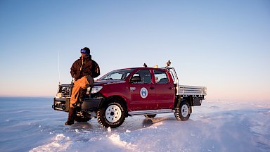 Well covered expeditioner sitting on front end of ute parked on the ice