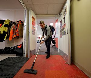 An expeditioner vacuums the floor.