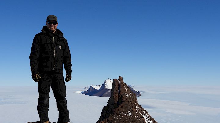 Expeditioner atop a mountain range near Mawson station