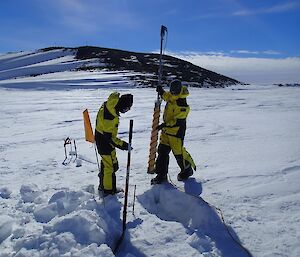 Two expeditioners with drill taking samples