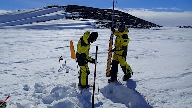 Two expeditioners with drill taking samples