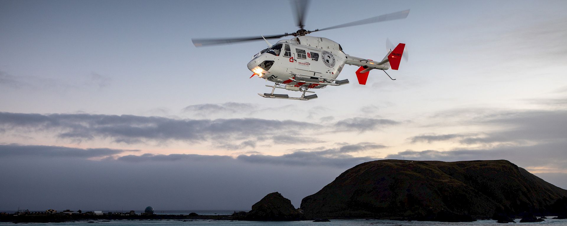 A helicopter hovering above the helipad of RSV Nuyina