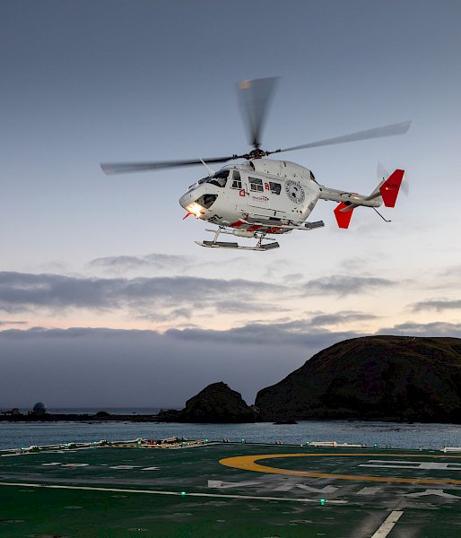 A helicopter hovering above the helipad of RSV Nuyina