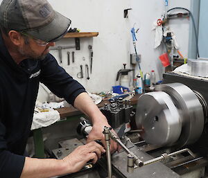 An expeditioner works on a turning machine.