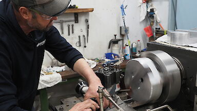 An expeditioner works on a turning machine.